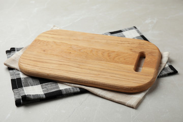 Wooden board and colorful kitchen towels on grey stone table