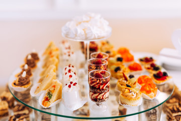 Candy bar. festive table with deserts, strawberry tartlet and cu