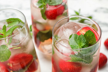 Glasses of refreshing drink with strawberry and mint on table, closeup view