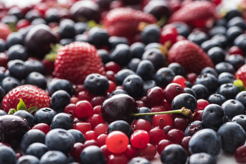 selective focus of red, fresh and ripe cranberries, strawberries, blueberries and cherries