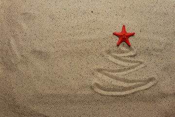 Christmas tree with starfish  on sand background