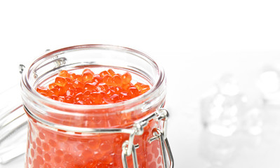 Plastic container with red caviar on white. Sea food. Healthy eating