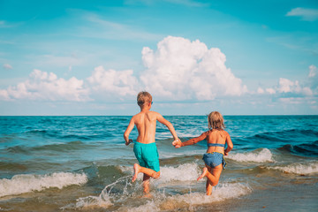 Obraz premium happy boy and girl run play at beach