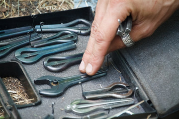 Close-up of a man's hand picks one of jaw harps, khomuses, folk musical instruments, selective focus