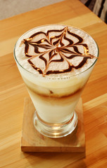 A Cup of  latte art coffee on wooden table
