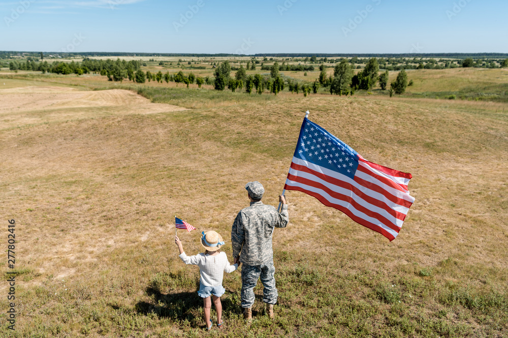 Canvas Prints back view of military man and patriotic kid holding american flags