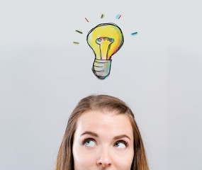 One light bulb with young woman looking upwards