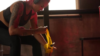 Female boxer wrapping hands with boxing wraps
