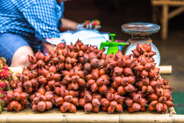 The background of the close-up fruit that is sold on the wooden table(rambutan,taking with a little thorn)is colorful,appetizing,sweet flavor,often cultivated according to the season, but the species