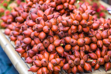 The background of the close-up fruit that is sold on the wooden table(rambutan,taking with a little thorn)is colorful,appetizing,sweet flavor,often cultivated according to the season, but the species