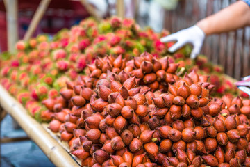 The background of the close-up fruit that is sold on the wooden table(rambutan,taking with a little thorn)is colorful,appetizing,sweet flavor,often cultivated according to the season, but the species