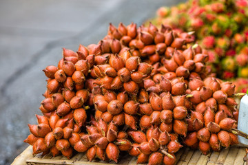 The background of the close-up fruit that is sold on the wooden table(rambutan,taking with a little thorn)is colorful,appetizing,sweet flavor,often cultivated according to the season, but the species