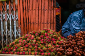 The background of the close-up fruit that is sold on the wooden table(rambutan,taking with a little thorn)is colorful,appetizing,sweet flavor,often cultivated according to the season, but the species