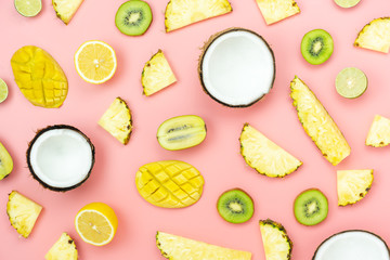 Table top view fruit tropical with spring summer holiday & vacation  background concept.Arrangement sliced various pineapple kiwi mango lemon and lime coconut on  pink paper.flat lay & pastel tone.