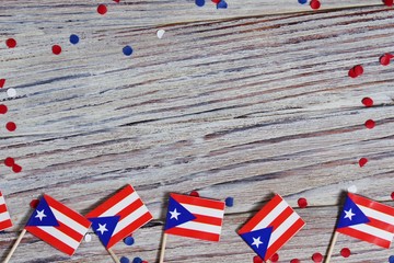 Puerto Rico independence day. day of constitution 25 July. the concept of veterans Day or memorial. mini flags and confetti on white wooden background. horizontal