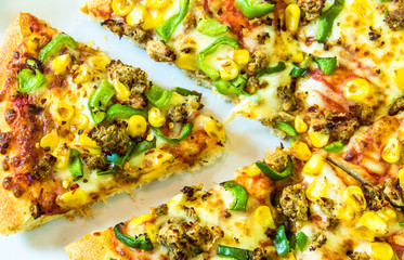 Fresh hot pizza with ketchup, mustard sauce, tomatoes, chilli flakes and oregano.