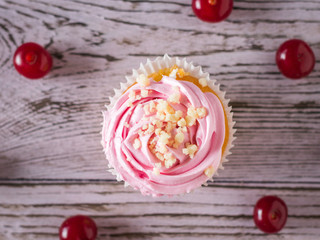 Fresh homemade cherry berry cupcakes on wooden table. Flat lay.