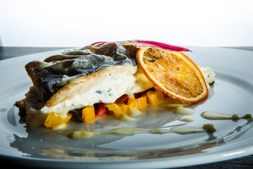 closeup roasted sea fish on pickled pepper garnish