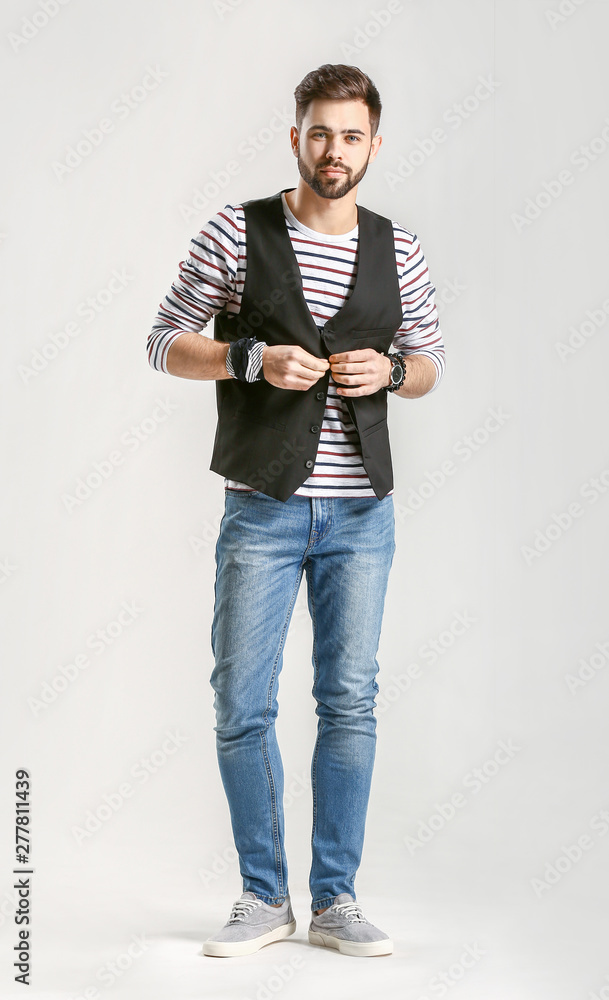 Wall mural Handsome stylish man on light background