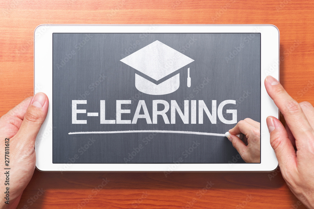Poster e-learning concept. closeup of hands touching white tablet computer on wooden desk. teacher writing 