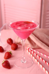 Glass of tasty summer cocktail with strawberry on table