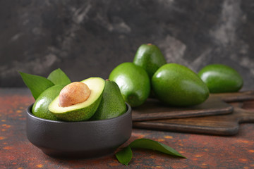 Bowl with fresh ripe avocados on table