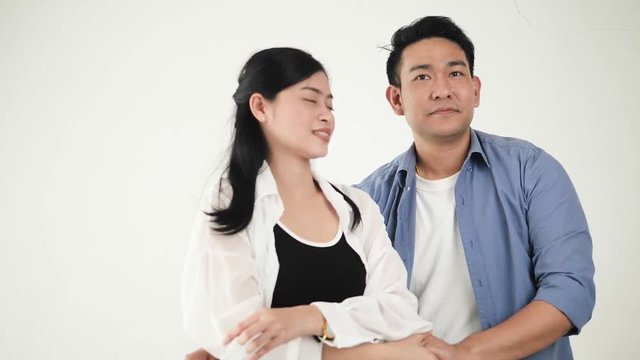 Happy Asian couple dancing together at home, slow motion.