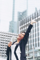 Successful beautiful Asian business  woman holding money US dollar bills in hand , business concept