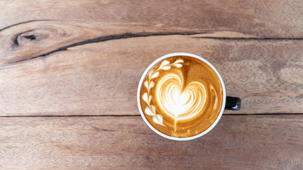 Hot art coffee cappuccino in a cup on wooden table background  with copy space