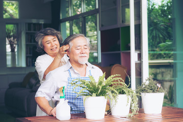 cheerful senior woman massaging head of elderly husband