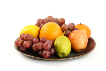 A heap of different tropical fruits isolated on Ceramic plate. Healthy and organic fair concept. - Image
