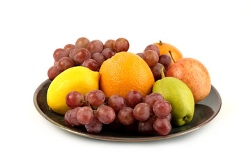A heap of different tropical fruits isolated on Ceramic plate. Healthy and organic fair concept. - Image