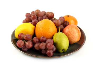A heap of different tropical fruits isolated on Ceramic plate. Healthy and organic fair concept. - Image