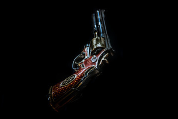 LONDON,ENGLAND,DECEMBER 10th,2018: pistol revolver isolated on black background. Jeweled revolver, customized .357 Magnum with red gold, red enamel and diamond decoration. Part of the Royal Armouries.