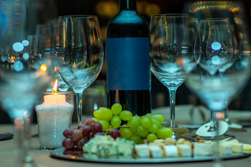 Space to write text. The concept of wine consumption. Wine bottle, a glass with grapes, bunches of grapes. A bottle of wine with space to writing. 