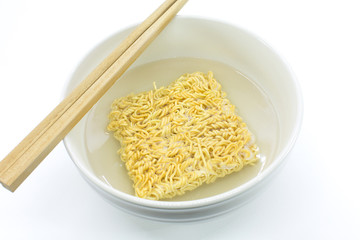 Famous home made asian instant noodle floating on boiled water in a ceramic bowl with chopsticks on white background. Horizontal shot.