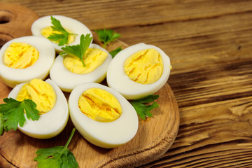 Boiled eggs with parsley on cutting board on a wooden table