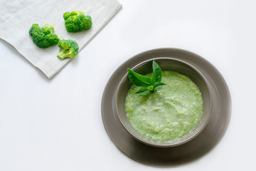 Vegetarian soup of broccoli puree on a white background. The concept of healthy eating.