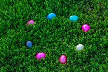 Multicolored eggs lying on green grass. Easter