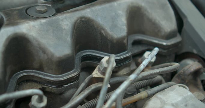 Parts to an old engine in car dirty in oli