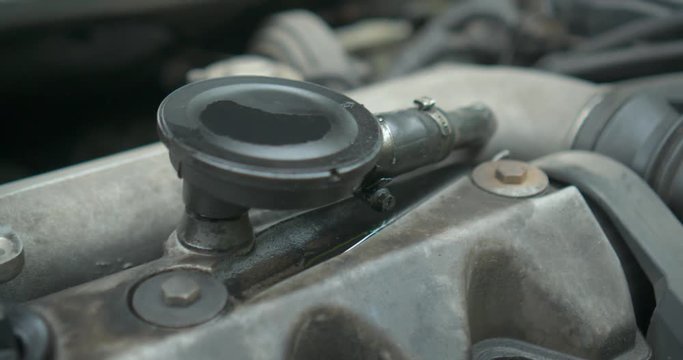Parts to an old engine in car dirty in oli