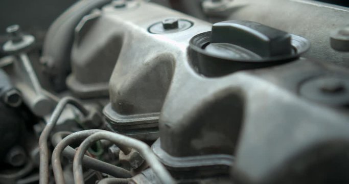 Parts to an old engine in car dirty in oli