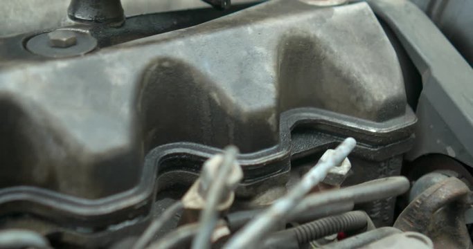 Parts to an old engine in car dirty in oli