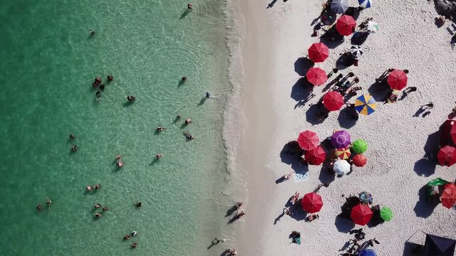 Aerial view of people having fun in a tropical beach and the blue ocean in Arraial do Cabo Rio de Janeiro Brasil.