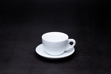 white cup of coffee on black background 
