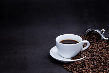 cup of coffee with beans and coffee machine on black background