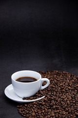 cup of coffee with beans on wooden background