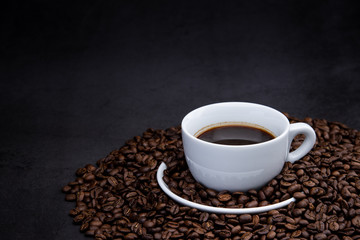 cup of coffee with beans on wooden background