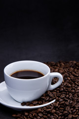 cup of coffee with beans on wooden background