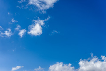 Fluffy white clouds against a bright, colorful blue sky